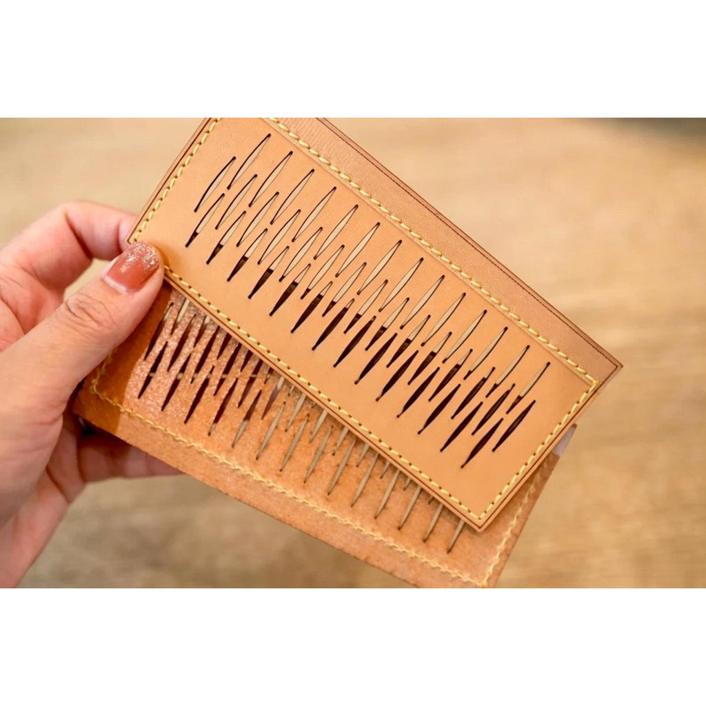 Hand holding tan leather wallet with laser-cut wave pattern and contrast stitching
