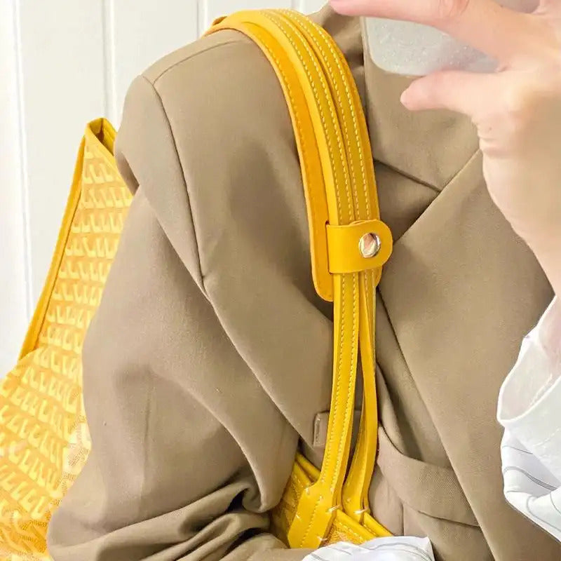 Bright yellow replacement bag strap with gold hardware, styled on a beige jacket for chic accessory upgrade.