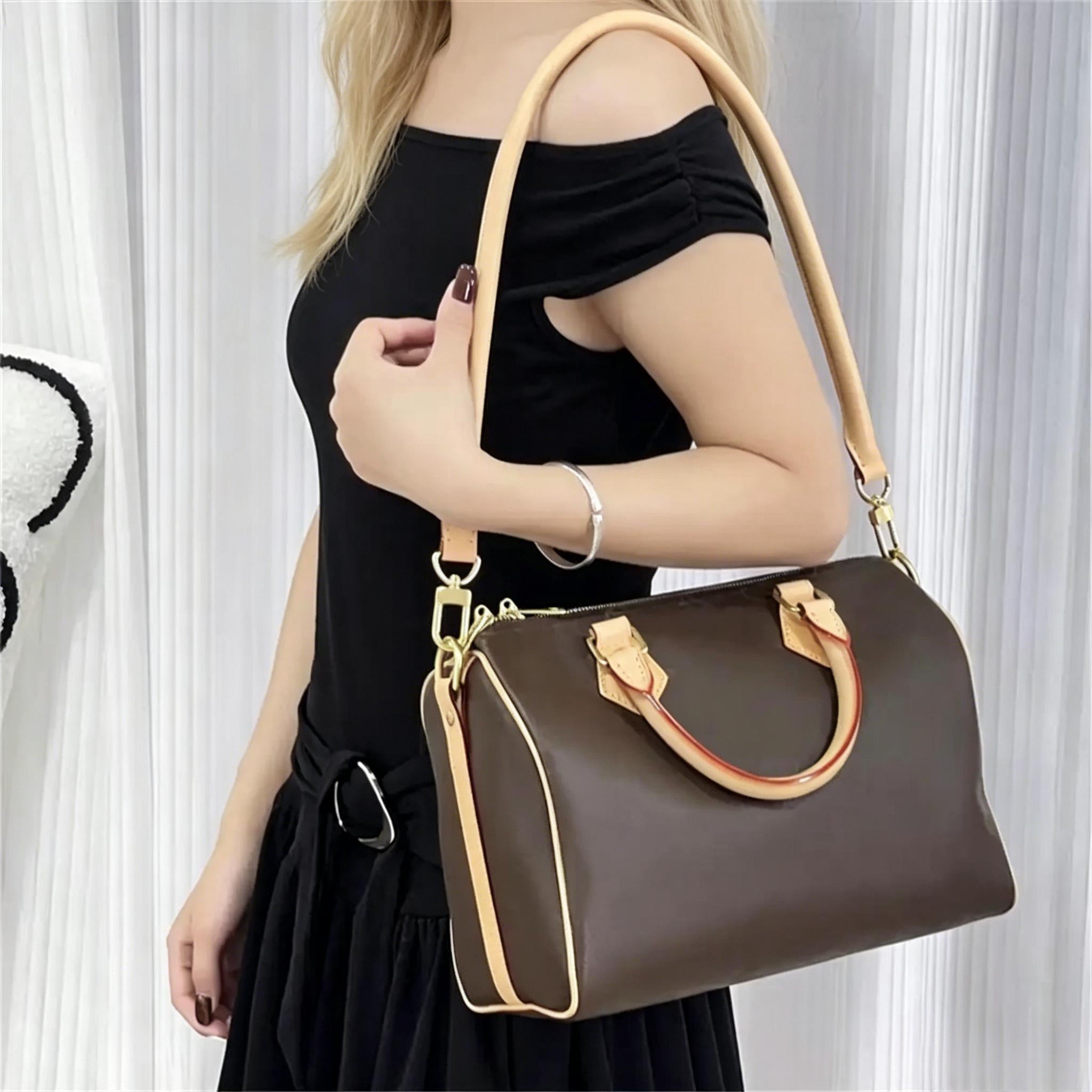 Brown leather handbag with tan straps and gold hardware, styled with black off-shoulder dress